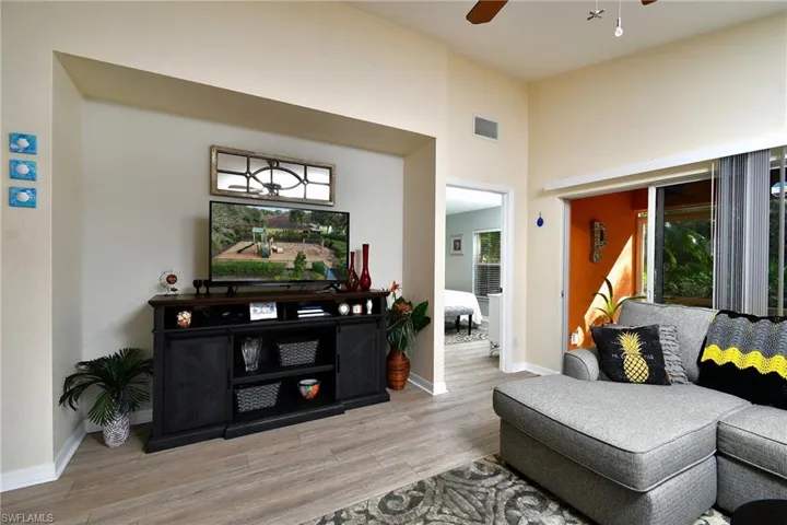Living area with sliders that lead out to the lanai; primary bedroom entry in the corner