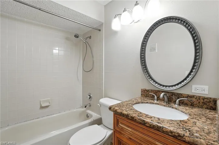 Full bathroom with shower / bath combination, vanity, and a textured ceiling