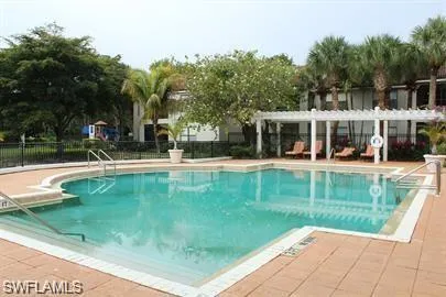 Community pool featuring a pergola and a patio area