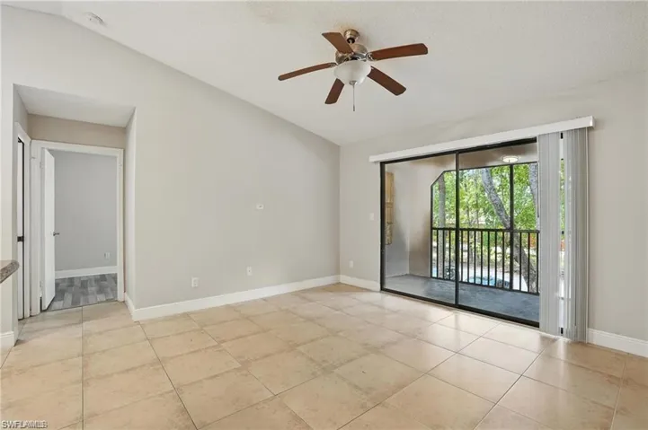 Unfurnished room with light tile patterned flooring, a ceiling fan, and lofted ceiling