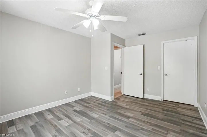Unfurnished bedroom with wood finished floors, a textured ceiling, and ceiling fan