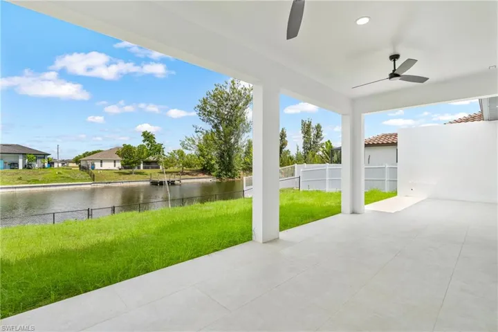 Spacious covered patio featuring ceiling fans, recessed lighting, and large format light-toned tile flooring