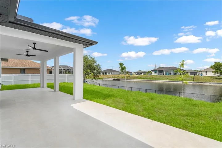 Covered lanai with ceiling fans, offering a concrete patio surface and views of the canal