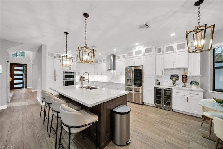 Kitchen with a notable chandelier, stainless steel appliances, a sink, and beverage cooler