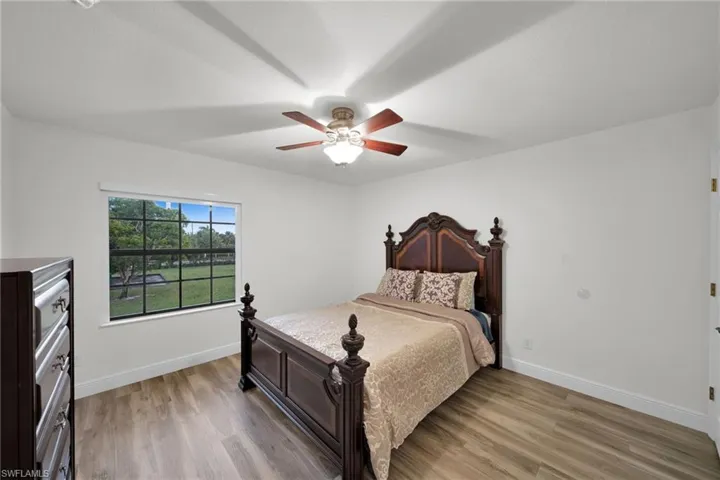 Bedroom featuring light wood-style flooring, baseboards, and ceiling fan