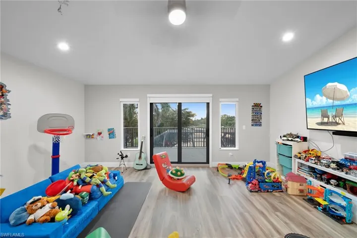 Recreation room with baseboards, wood finished floors, and recessed lighting