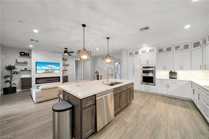 Kitchen featuring white cabinets, appliances with stainless steel finishes, a sink, and visible vents