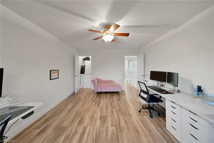 Office featuring baseboards, a ceiling fan, and light wood-type flooring