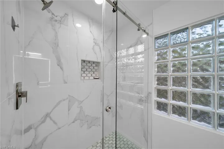 Bathroom with a marble finish shower
