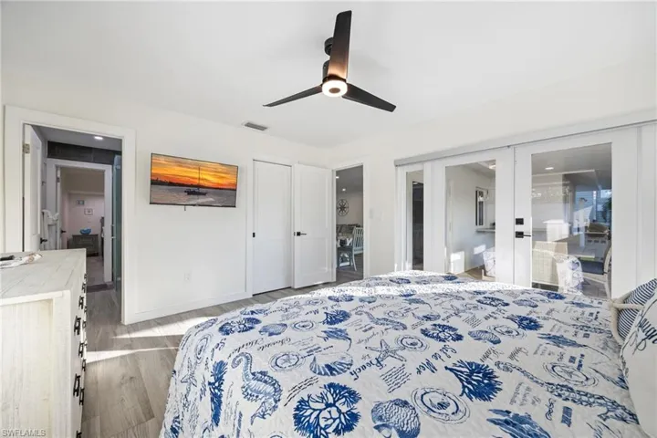 Primary Bedroom featuring a closet, wood finished floors, a ceiling fan, and french doors