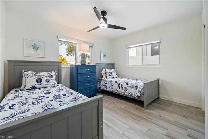 Bedroom with multiple windows, ceiling fan, and light wood finished floors