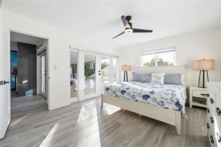 Primary Bedroom featuring access to exterior, ceiling fan, and wood finish floors