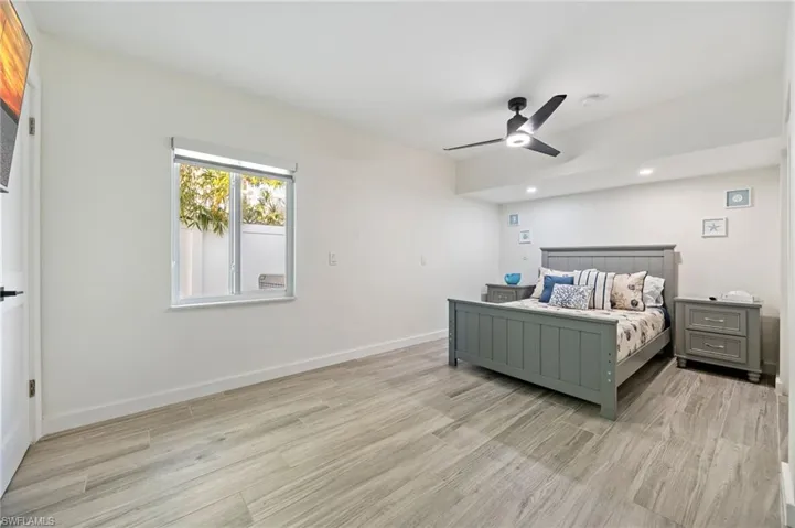 Bedroom with light wood-style flooring, ceiling fan, and recessed lighting