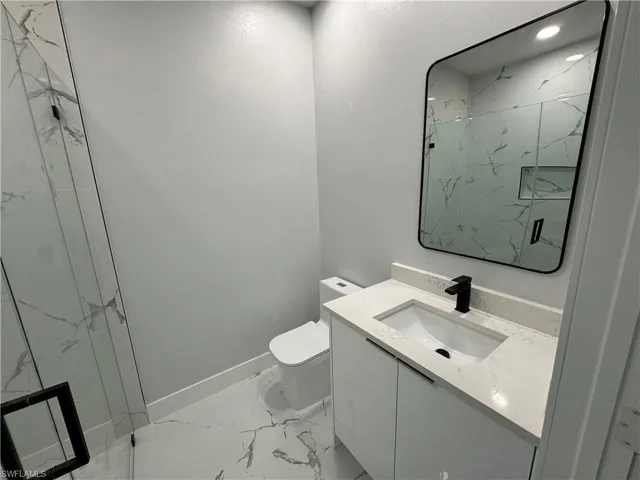 Bathroom with vanity, toilet, and walk in shower