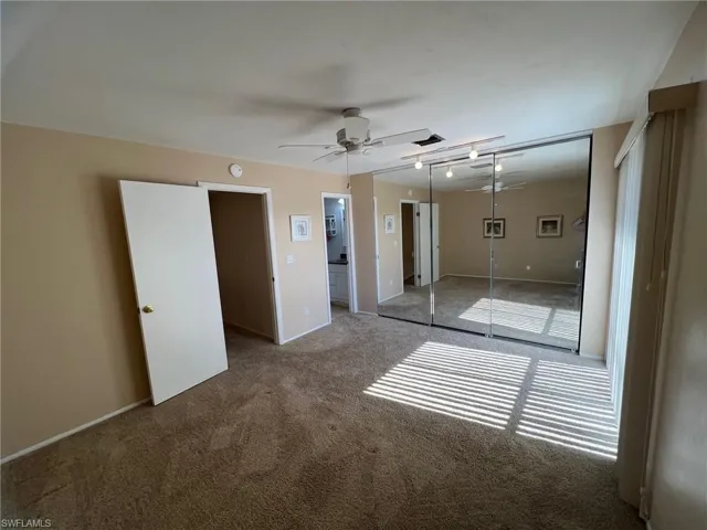 Bedroom 1 featuring a closet, carpet, ensuite bathroom, ceiling fan