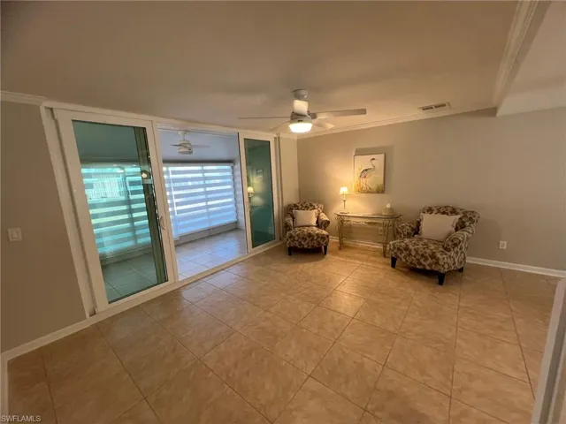 Living area featuring ornamental molding and a ceiling fan