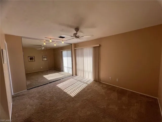 Bedroom 1 and mirrored closet featuring a ceiling fan and Juliette balcony