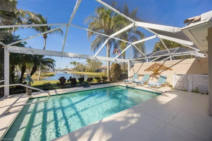 View of swimming pool featuring a water view, a patio area, and a lanai