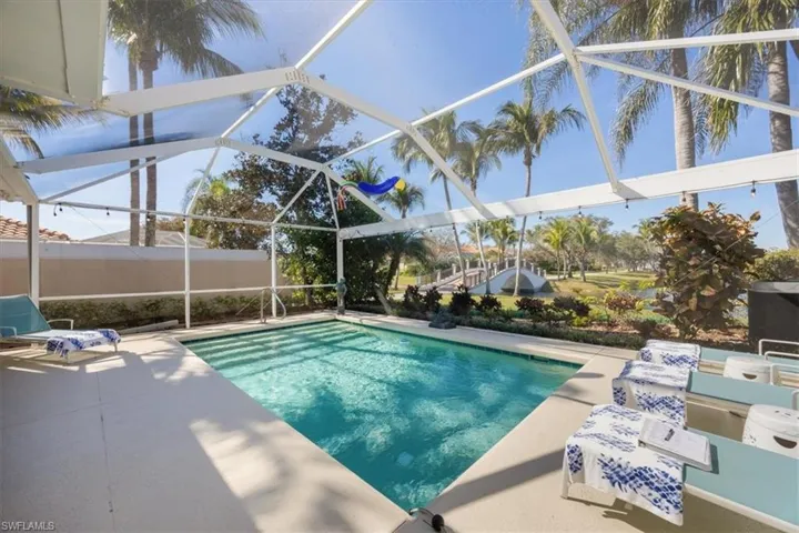 View of pool featuring a patio area and glass enclosure