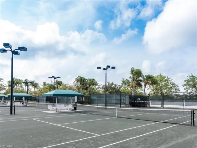 View of tennis court with a water view