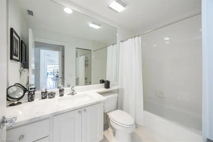 Full bathroom featuring vanity, shower / bath combination with curtain, and toilet