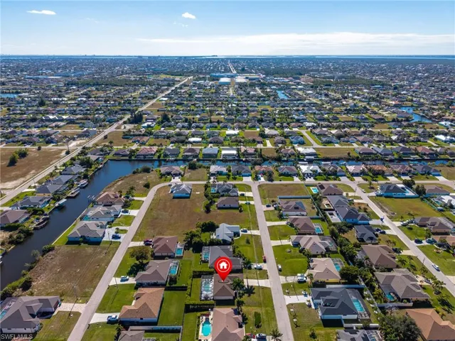 Aerial view of property and surrounding area featuring nearby suburban area and a nearby body of water