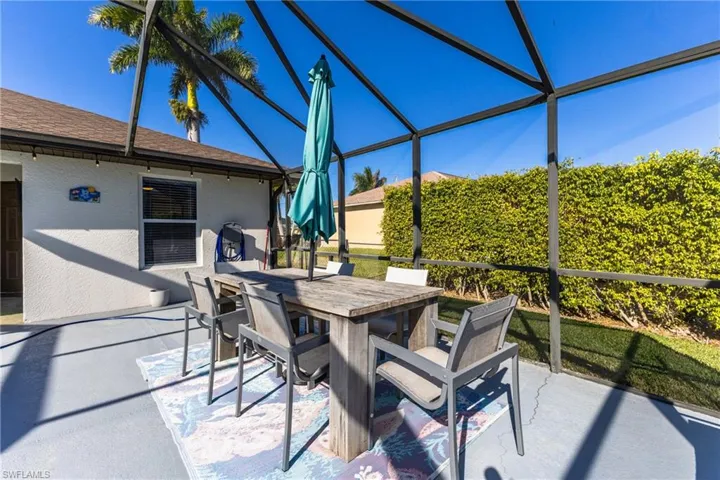 View of patio with a lanai, outdoor dining space, and a sunroom