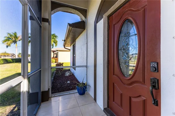 Doorway to property featuring a sunroom and stucco siding