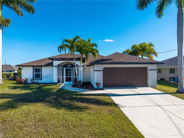 Single story home with stucco siding, a front yard, concrete driveway, and a garage