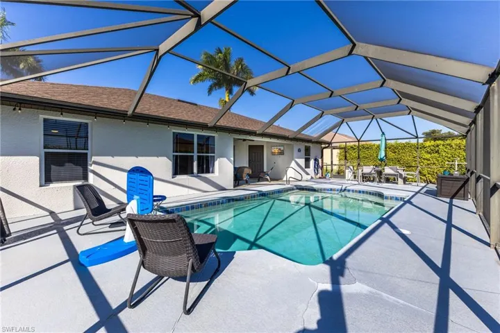 Swimming pool featuring a sunroom, a patio, and glass enclosure