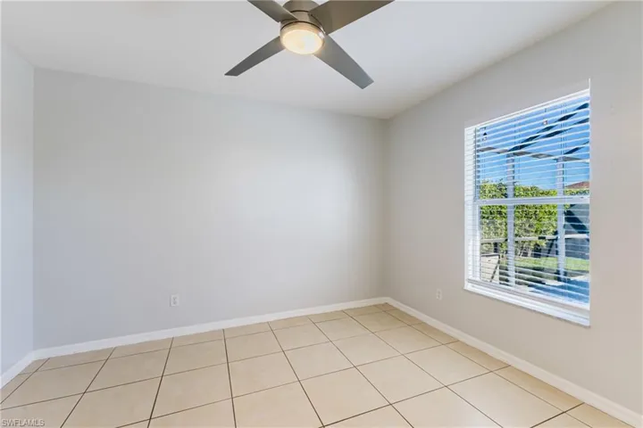 Spare room with ceiling fan and light tile patterned floors