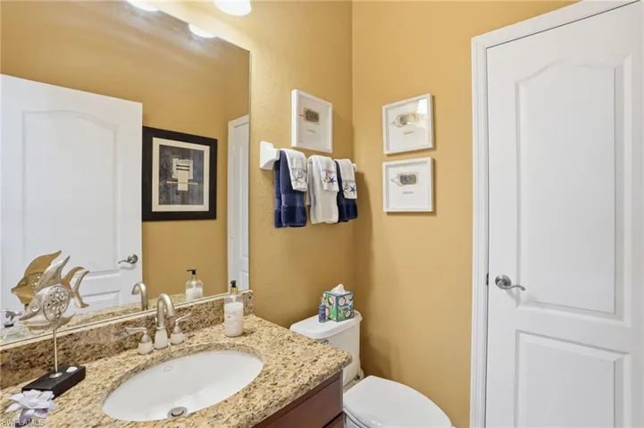 Half bath with vanity and a textured wall