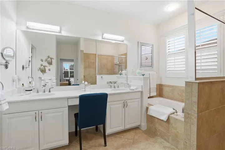 Full bathroom featuring double vanity, a bath, tiled shower, and light tile patterned floors