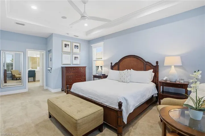 Bedroom with a raised ceiling, light carpet, ceiling fan, crown molding, and recessed lighting