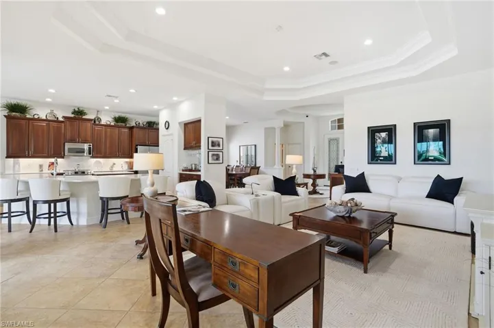 Dining area featuring a tray ceiling, recessed lighting, light tile patterned floors, and crown molding