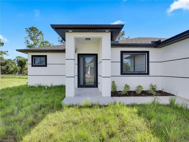 Doorway to property featuring stucco siding