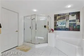 Full bathroom featuring tile patterned flooring, a bath, and a shower stall