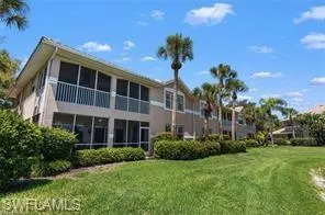 Back of house with a sunroom, a yard, and a balcony