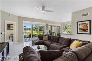 Living area featuring a ceiling fan and tile patterned floors