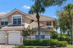 View of front of home with stucco siding, an attached garage, a tiled roof, and driveway