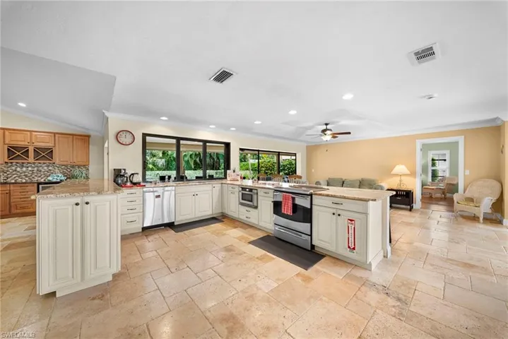 Spacious kitchen featuring an island, light-toned cabinetry, stainless steel appliances, recessed lighting, and tile flooring