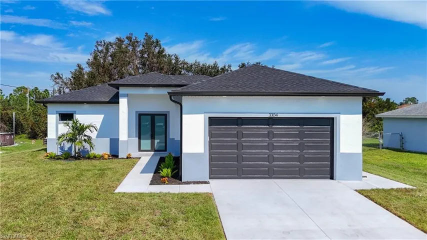 View of front of house featuring a front lawn and a garage