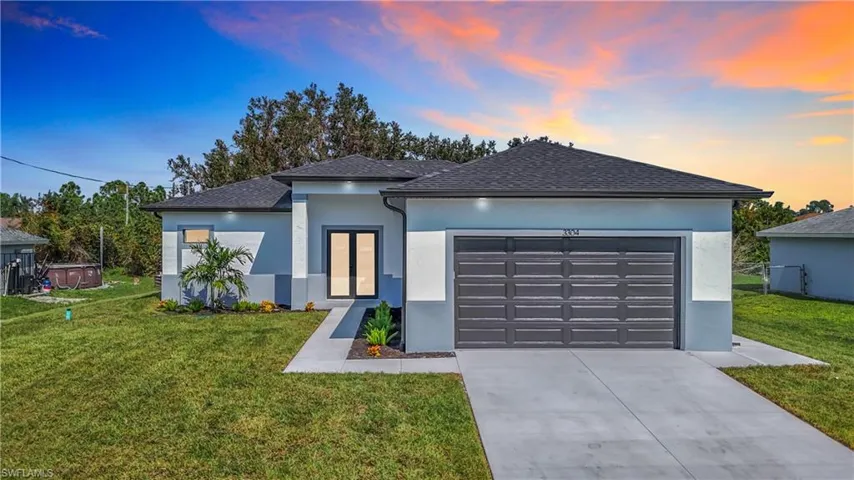 View of front of house with a garage and a lawn