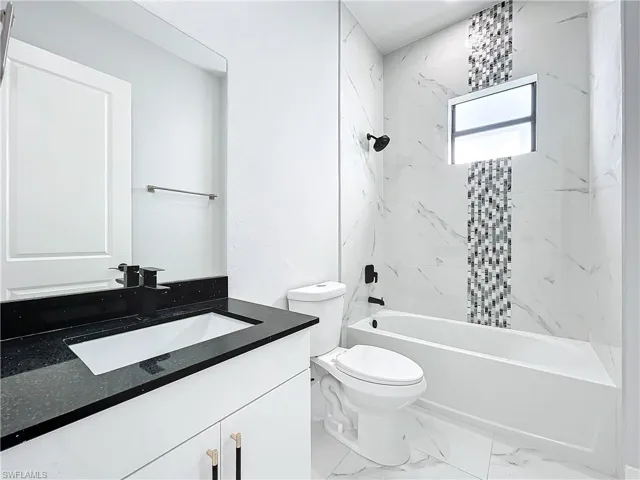 Full bathroom featuring vanity, toilet, and tiled shower / bath
