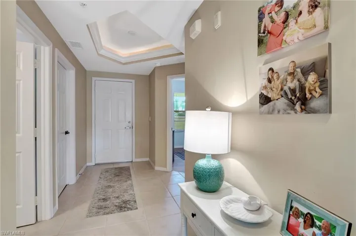 Foyer featuring a tray ceiling and light tile patterned flooring