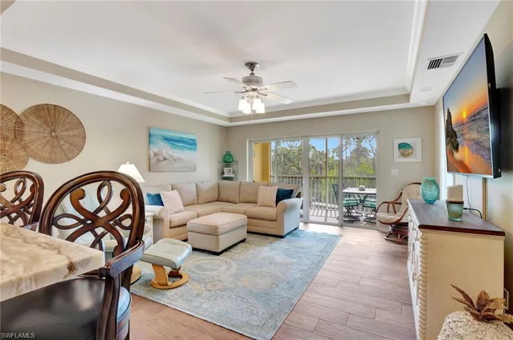 Living room with a raised ceiling, crown molding,