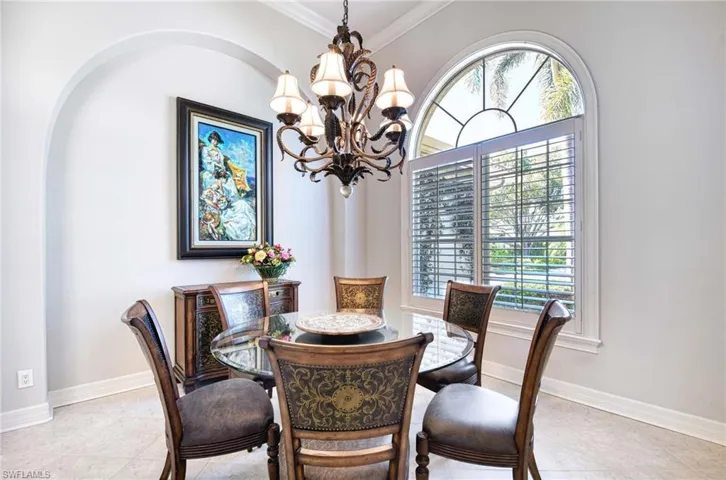 Dining space featuring a chandelier, ornamental molding, and light tile patterned flooring