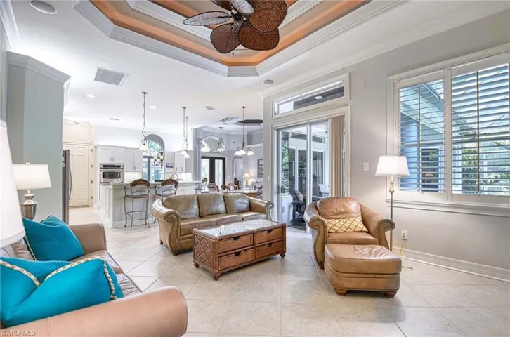 Living area featuring ornamental molding, a chandelier, a ceiling fan, light tile patterned flooring, and recessed lighting