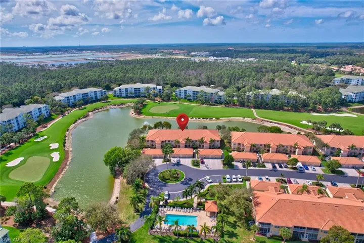 View of condo,golf course, a water viewwith water feature, and pool across from condo