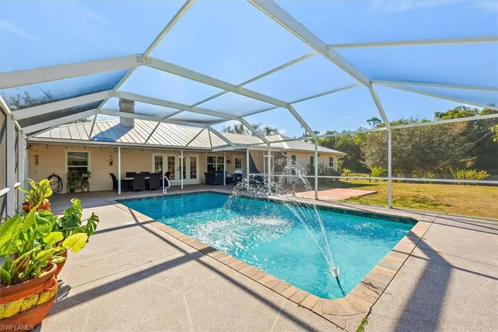 Outdoor pool with french doors, a sunroom, glass enclosure, and a patio